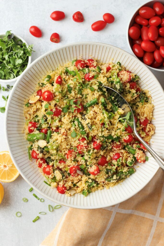 The couscous salad is in a large salad bowl and is ready to eat.