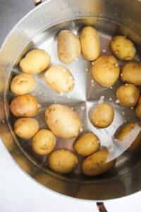 The potatoes are boiling in a pot.