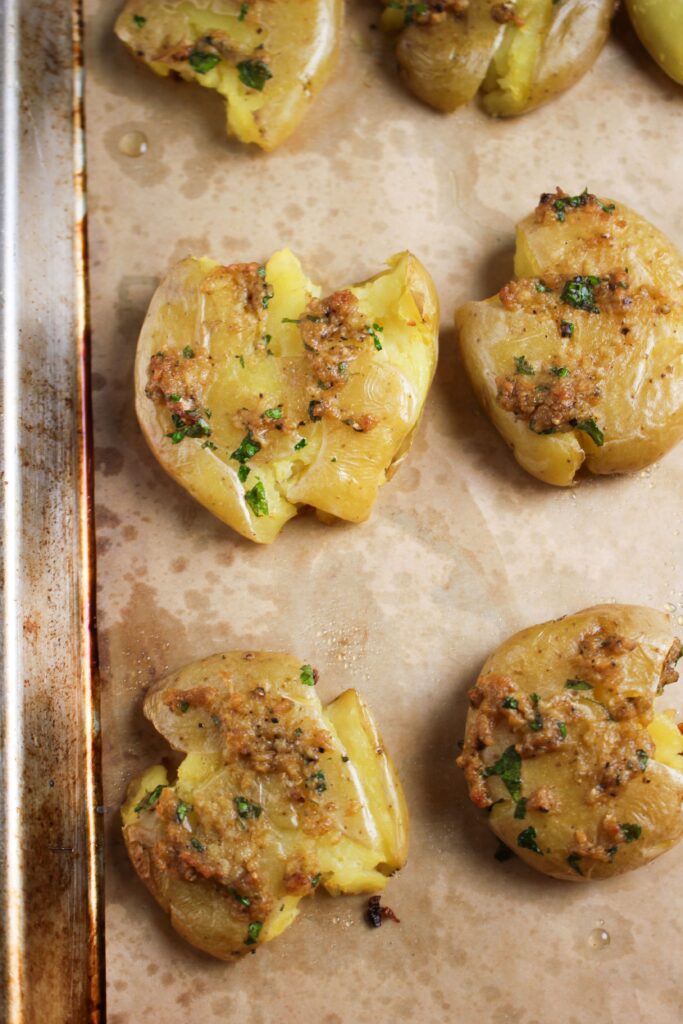 The potatoes are on a pan and hot out of the oven.