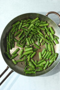 Grilling the asparagus in a pan.