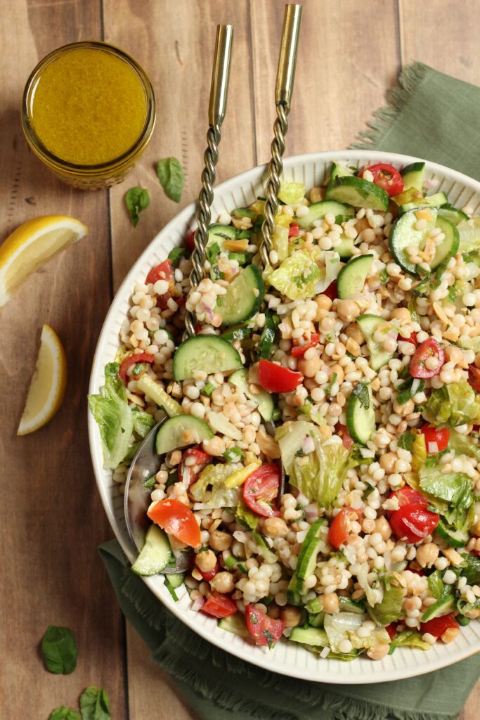 An up close picture of this couscous salad in a large salad bowl.