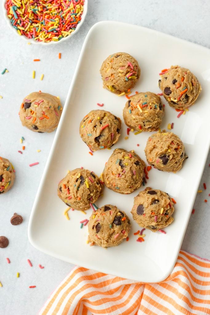 The cookie dough protein balls are on a white platter.