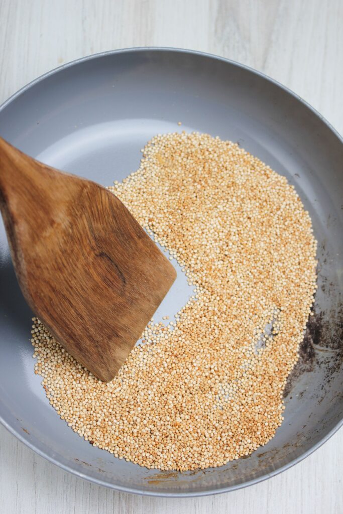 Toasting the quinoa in a pan.