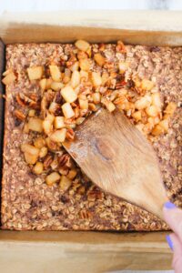 Adding the apple topping to the top of the baked oatmeal.