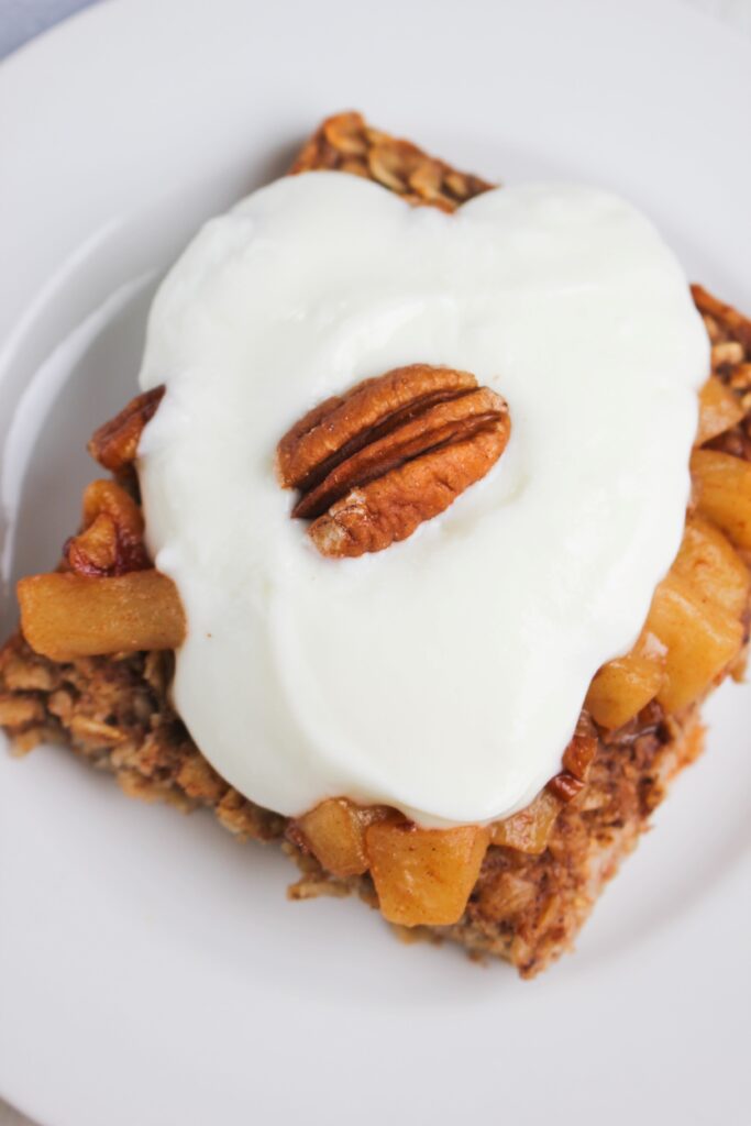 An up close picture of a slice of this apple pie baked oatmeal with yogurt on top.