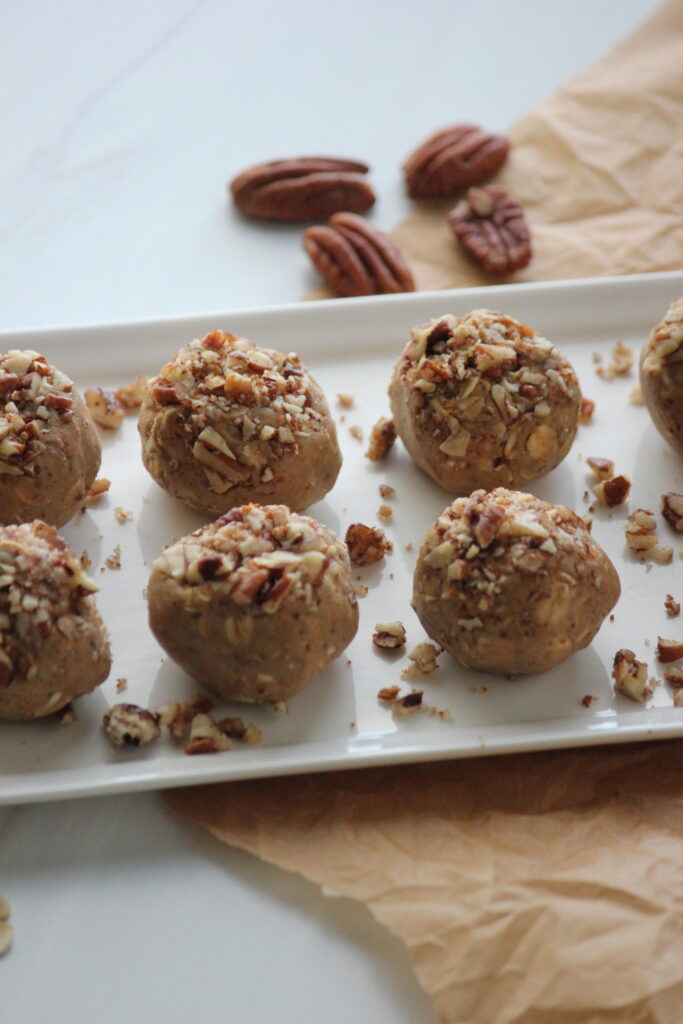 The protein balls are now topped with crushed pecan pieces.