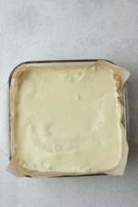 The white chocolate has been poured over the rice krispie treats.