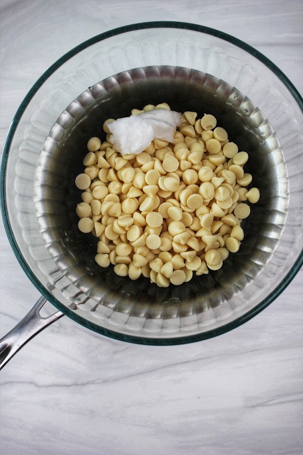 The white chocolate chips and coconut oil in a pan.