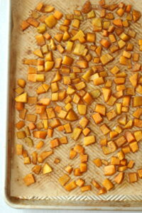 The finished roasted butternut squash cubes on a pan.