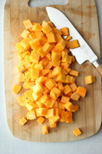 Cutting the butternut squash into smaller chunks.