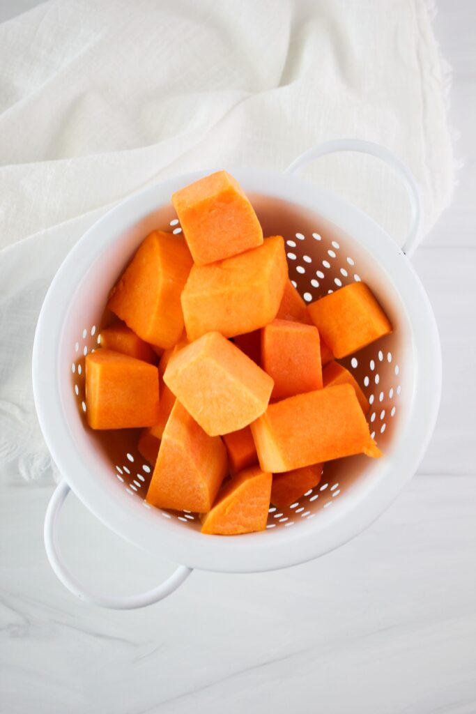 The butternut squash has been washed in a colander.