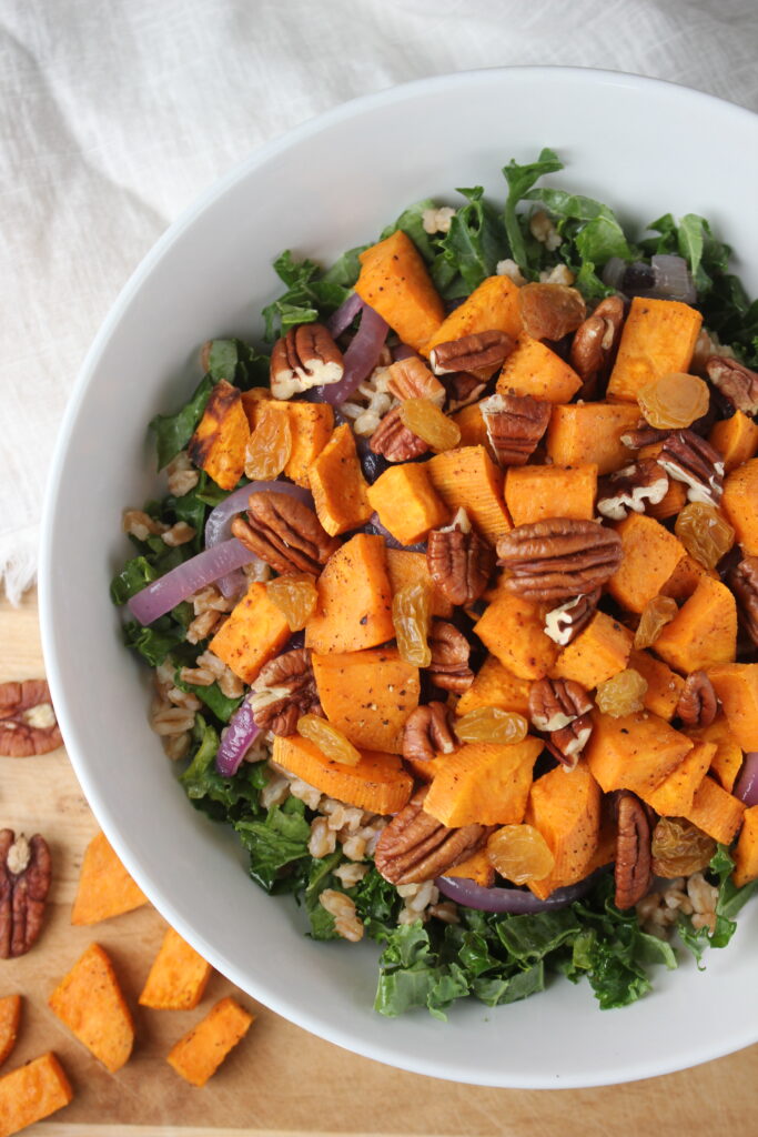 The kale and sweet potato salad in a large salad bowl and ready for the dressing.