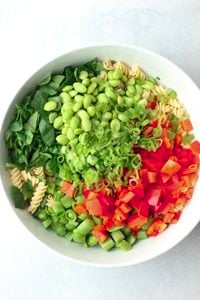 All of the salad ingredients have been added to a large white bowl.