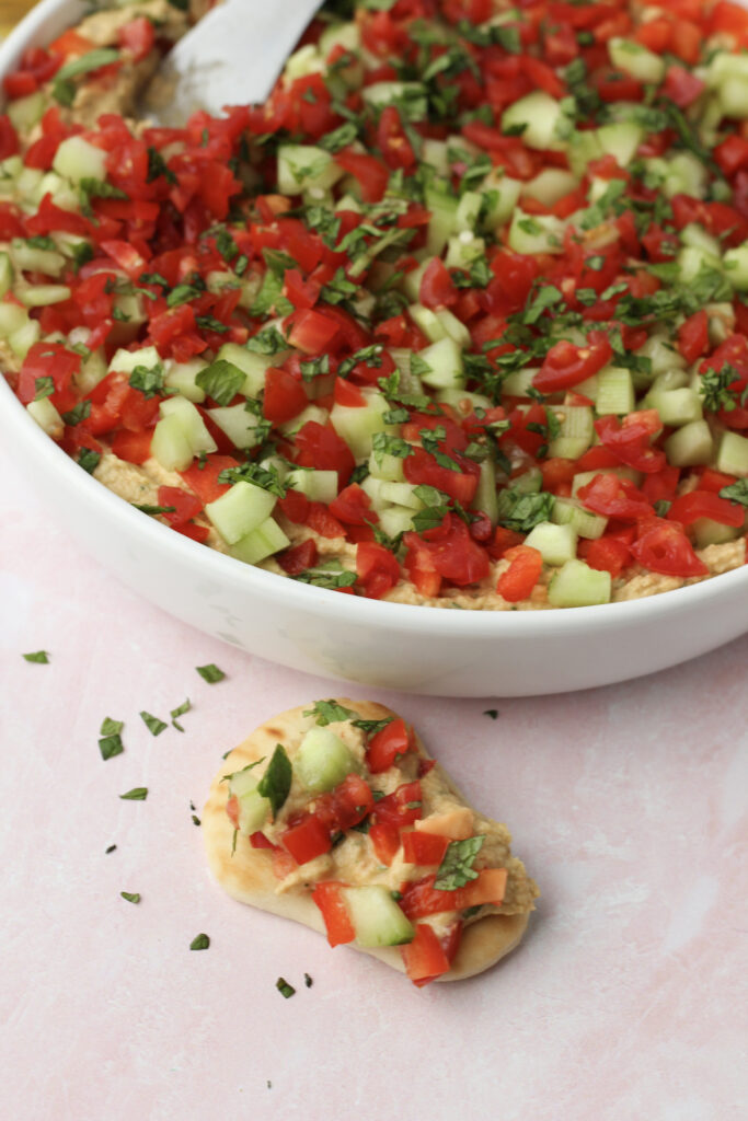 The bean dip has been spread onto a small pita bread and is ready to eat.