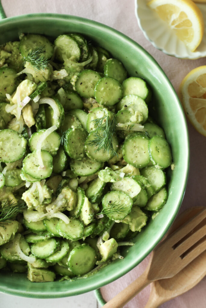 An up-close picture of the cucumber salad in a green bowl.