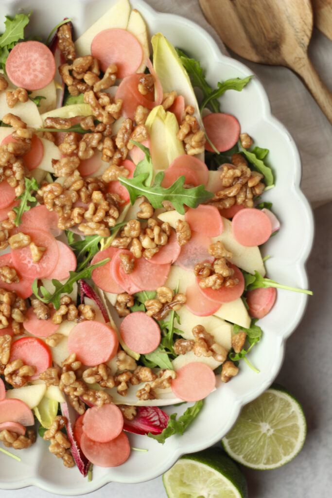 The candied walnuts have been added to an arugula salad.