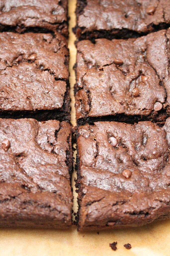 Warm vegan brownies fresh out of the oven and cut into squares.