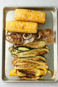 The vegetables have been grilled on a BBQ and placed on a sliver tray.