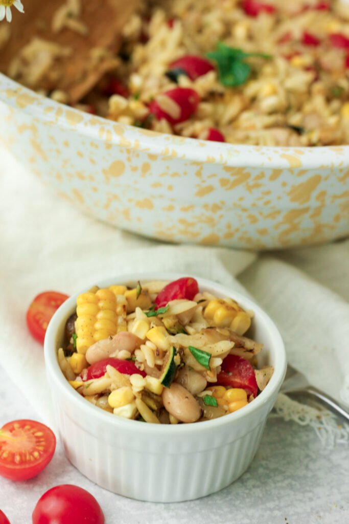 The garden vegetable orzo salad has been served into a small ramekin.