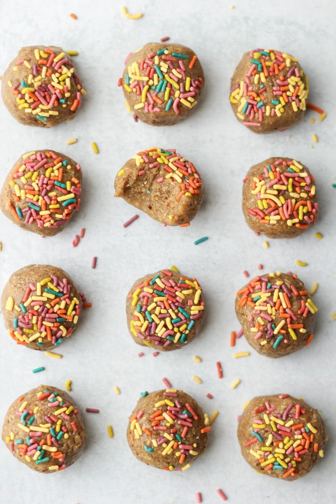 THe protein balls are lined up and there is a bite out of one of them.