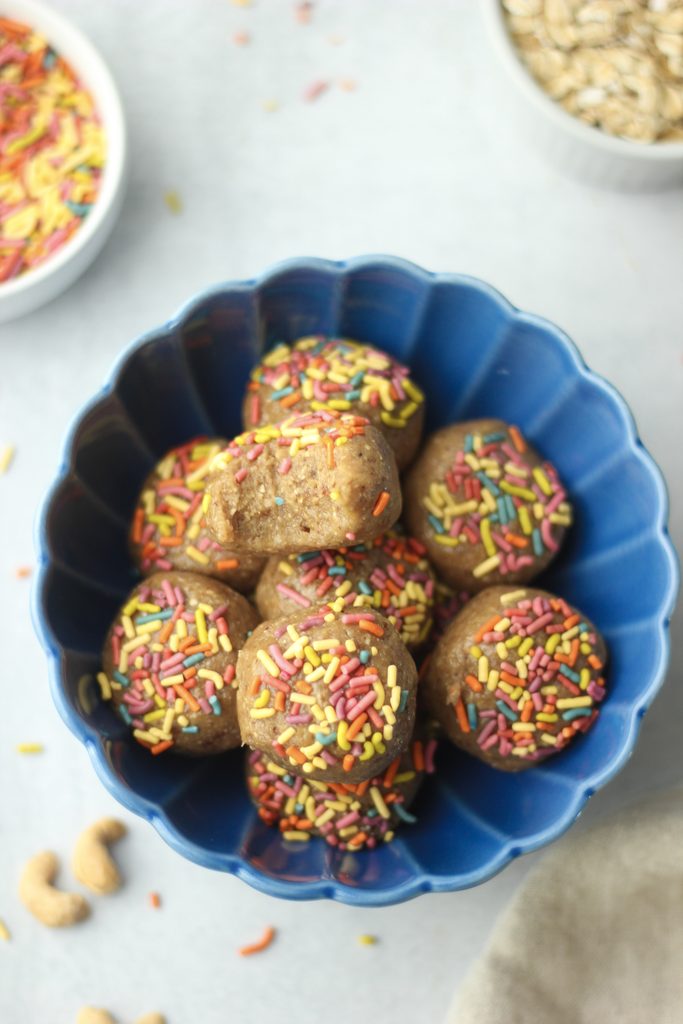 The cashew bites are in a blue bowl and there is a bite out of one of them.