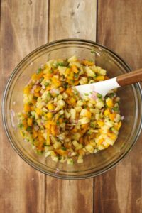 All of the ingredients have been tossed in a glass bowl.