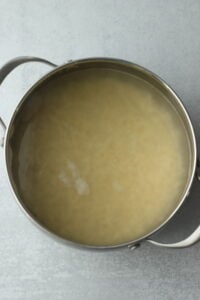 The orzo is cooking in a pan.