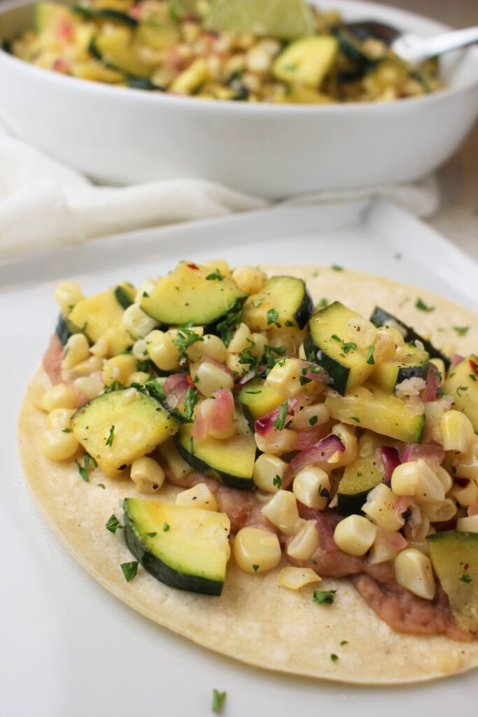 The zucchini and corn sauté on top of a bean taco.
