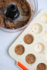 Starting to press the crust into the cupcake mold.