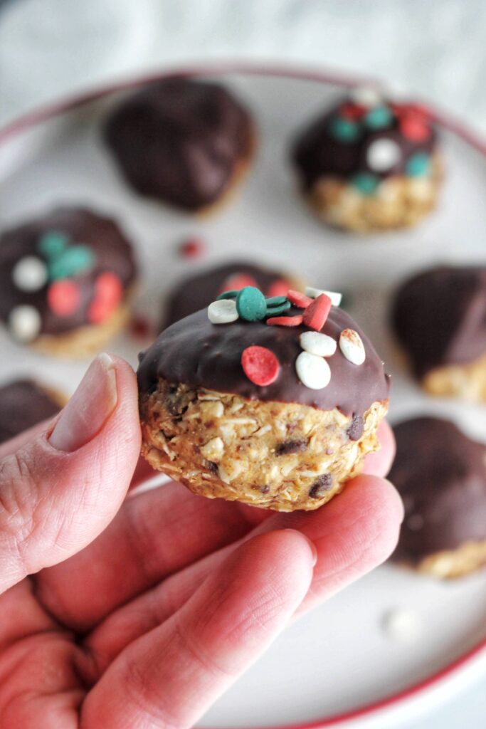 Holding one festive peanut butter oatmeal ball.