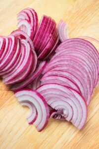 SLlced red onion on a cutting board.