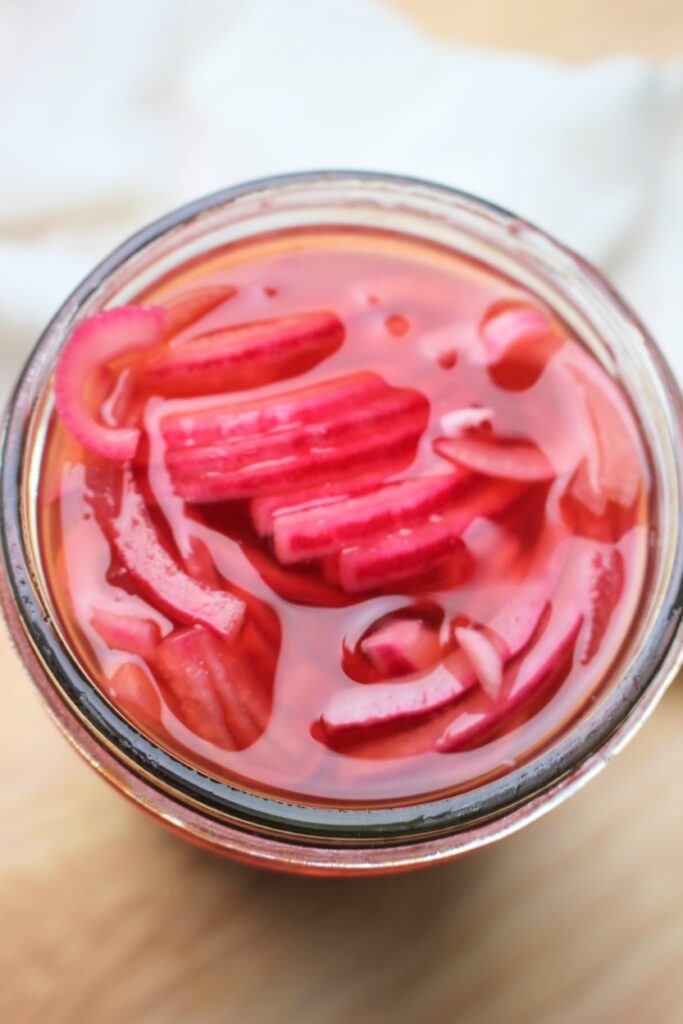 Looking into a jar of red pickled onions.