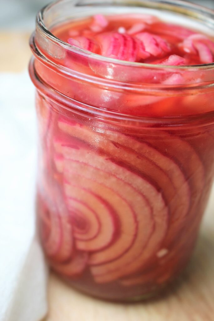 A side angle of the mason jar of pickled onions.