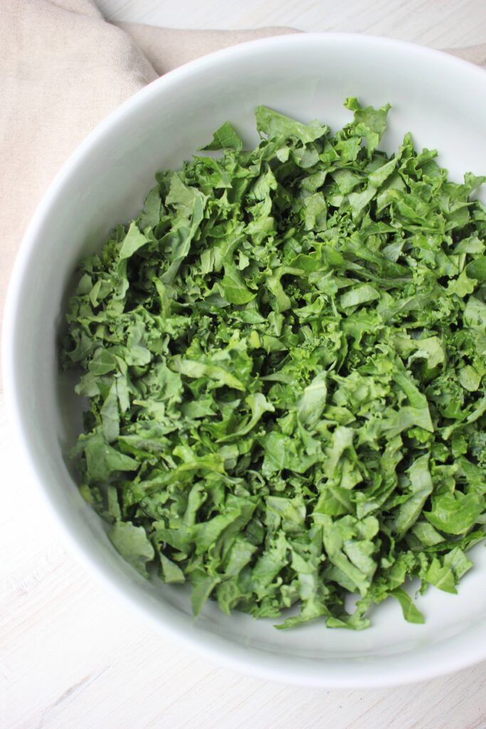 A bed of kale in a large white salad bowl.