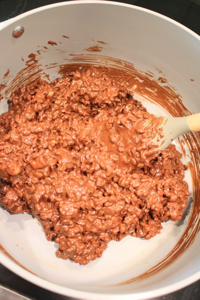 Mixing the peanut butter mixture into the cereal.