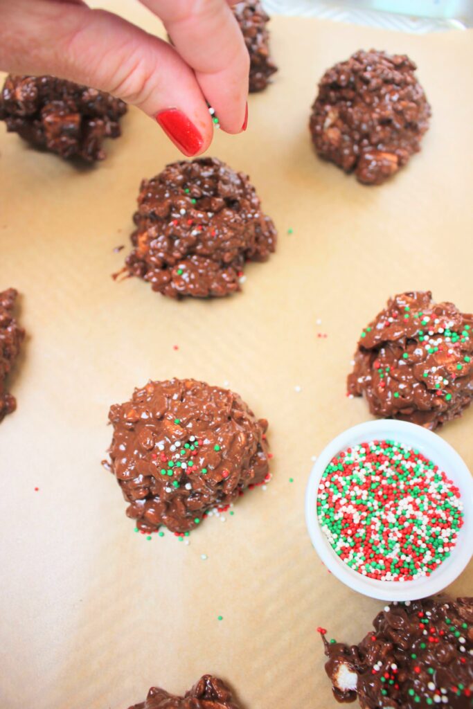 Adding sprinkles to the tops of the cookies.