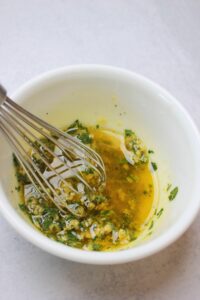 All of the ingredients for the garlic sauce have been added to a small white bowl.