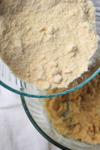 Pouring the dry ingredients into the bowl of wet ingredients.