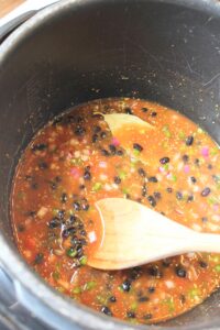 Stirring all of the ingredients together in the pressure cooker.