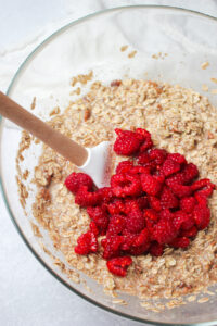 Folding in the fresh raspberries with a spatula.