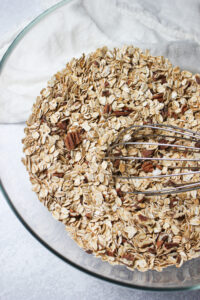 Stirring all of the dry ingredients in a glass bowl.