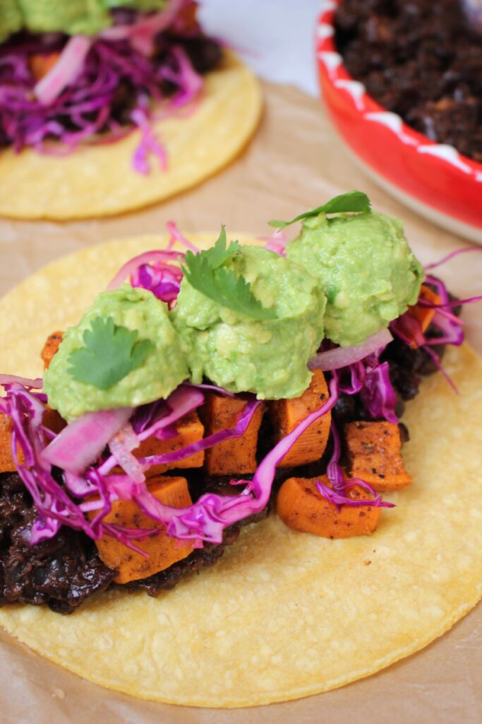 An up close picture of a roasted sweet potato and black bean taco.