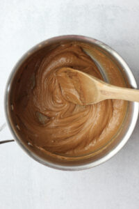 Mixing the peanut butter and maple syrup in a pot.