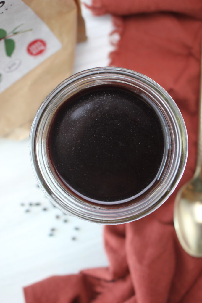 Elderberry syrup is ready to consume in a mason jar.