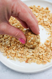 Rolling the balls into chopped peanuts.