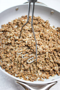 Mashing the lentils with a potato masher.