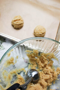 Using a cookie scoop to scoop out 12 even balls of dough.