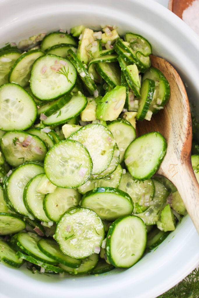The cucumber salad was just tossed and is ready to eat.