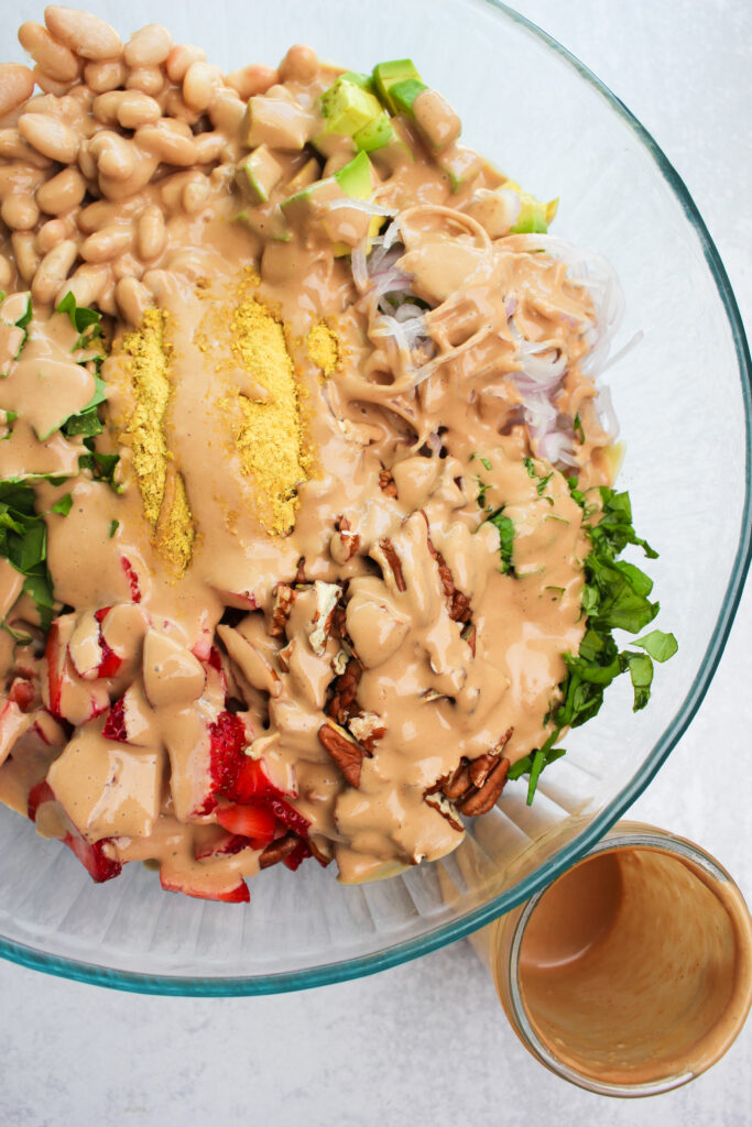 The dressing is poured onto the pasta salad and is ready to be tossed.
