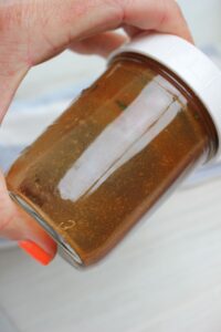 The dressing is being shaked in a mason jar.